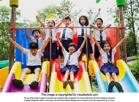 Group Indian School Kids Students Playing Sliding-Jhulla Having-Fun In-Park