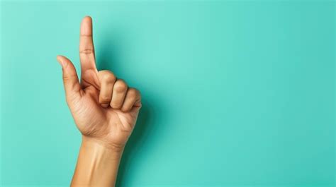 Premium Photo | Hand pointing upwards against a turquoise background