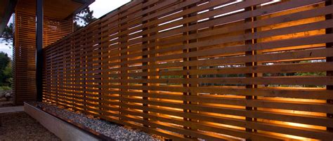 Horizontal Slatted Fence with pebble retaining wall | Wood slat wall, Wood wall design, House ...