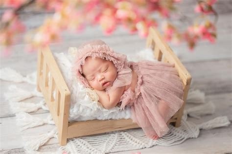 Premium Photo | Cute and adorable Asian newborn baby girl sleeping on bed withpink flower in ...