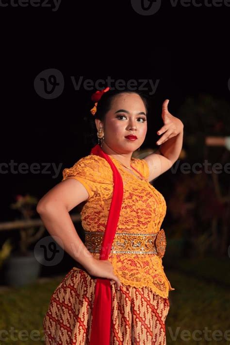 Balinese dancers in yellow color traditional costumes present the dance ...