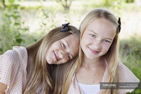 Portrait of two girls smiling, focus on foreground — sunlight, looking at camera - Stock Photo ...