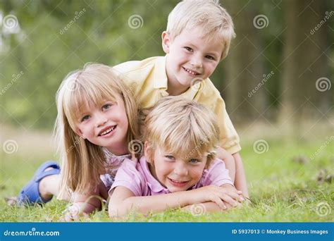 Three Young Children Playing Outdoors Smiling Stock Image - Image of ...