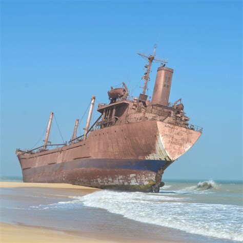 an old rusted ship sitting on the beach