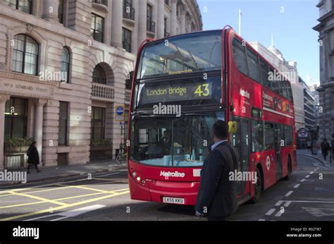 Man looking at double decker bus in London, UK Stock Photo - Alamy