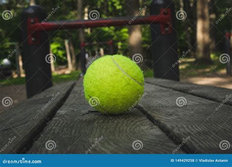 Yellow Tennis Ball with a Racket on the Street Court Stock Photo ...