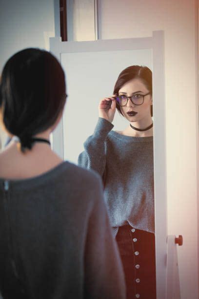 beautiful young woman standing in front of mirror and looking at her | Woman standing, Women ...