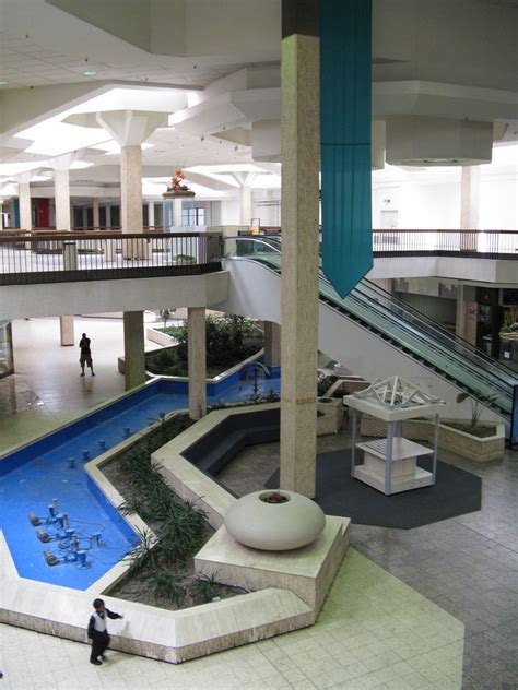 A small child plays near a dry fountain - Randall Park Mall, North ...