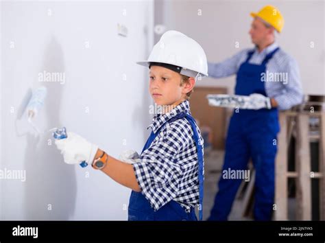 Boy painting wall, renovating home with father Stock Photo - Alamy