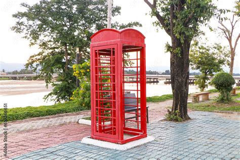 Old Red phone booth located on side to river with evening atmosphere ...