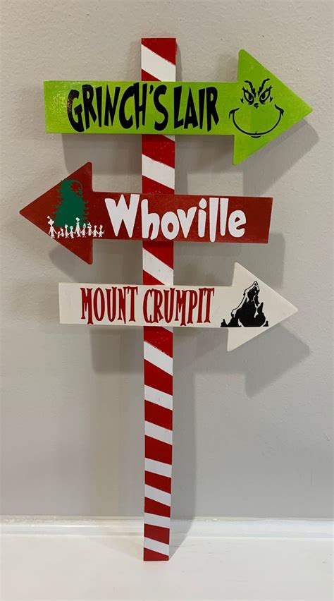 a wooden sign with multiple directions on it that says grinch's fair, whoville, mount crumpt