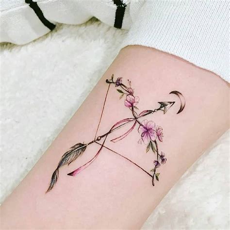 Small floral bow and arrow tattoo pointing to a crescent moon on her ...