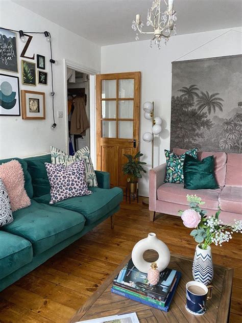 a living room filled with green couches and pink chairs next to a wooden coffee table