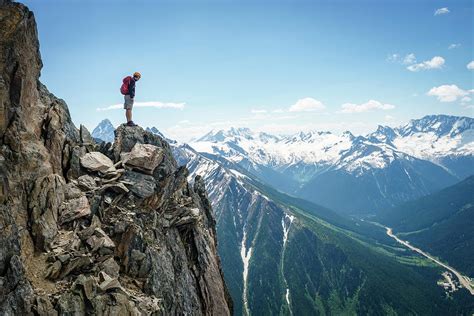 Male Mountaineer Standing On The Edge Of A Cliff Looking Down, Canada ...