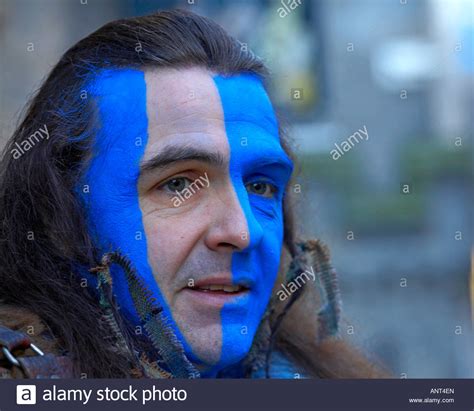 A Charity performer with the Scottish flag facepaint and dressed in a Scottish Braveheart ...