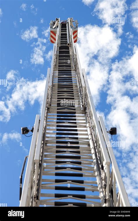 Fire truck ladder leading up into blue sky Stock Photo - Alamy