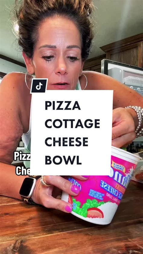 a woman sitting at a table with a sign in front of her that says pizza cottage cheese bowl