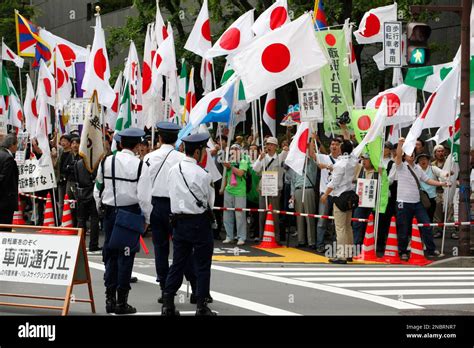 Protesters wave Japanese flags as they gather in front of the ...