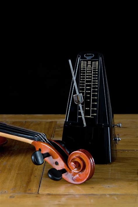 Metronome And Violin On Wooden Table Photograph by Junior Gonzalez - Fine Art America