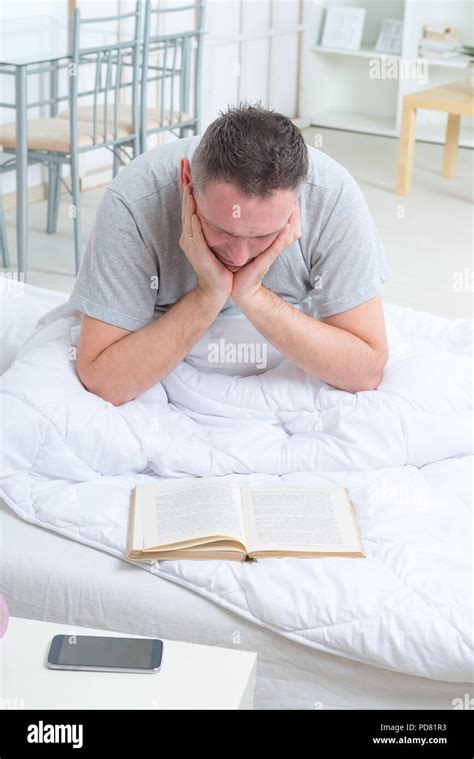 Man reading book in bed Stock Photo - Alamy