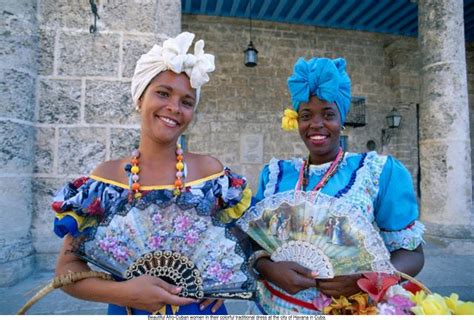 Beautiful Afro-Cuban women in their colorful traditional dress at the city of Havana in Cuba ...