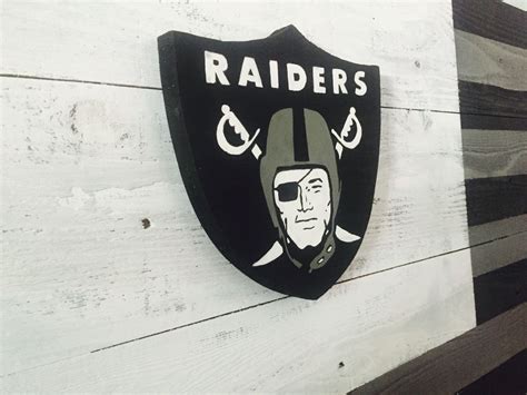 the oakland football team logo is painted on a wooden wall with black ...