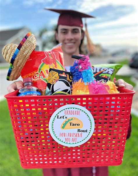 a person in a graduation cap holding a red basket filled with candy and candies