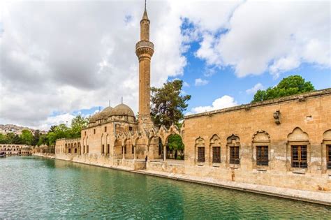 an old building next to a body of water with a tall tower in the background