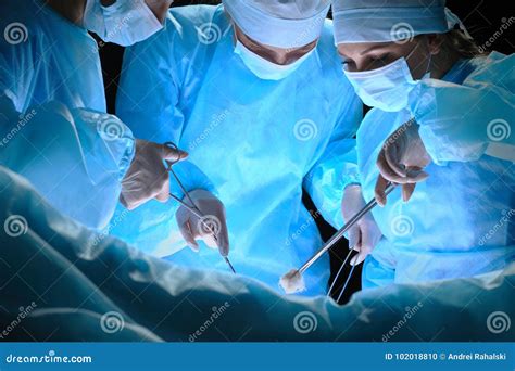 Group of Surgeons at Work in Operating Theater Toned in Blue Stock Photo - Image of scrubs ...