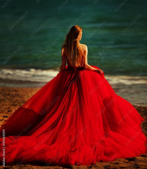 Beautiful girl by the sea. A woman in a red dress on the beach. Stock Photo | Adobe Stock