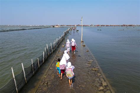 Suffering from climate change: Residents adapt to rising sea levels as Indonesian village sinks ...