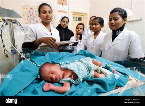 Doctors and nurse sisters at the bed of a premature baby in the ...