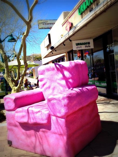 a pink couch sitting on the sidewalk in front of a store