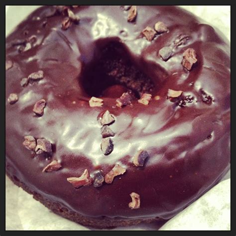 there is a chocolate donut with nuts on it