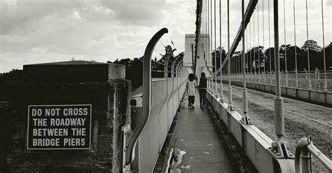 Two People Walking on the Sidewalk of the Bridge · Free Stock Photo