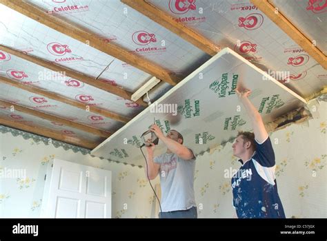 Builders installing high performance Kingspan and Celotex thermal insulation boards to the walls ...