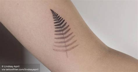 Silver fern tattoo on the inner arm.