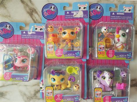 four littlest pet shop toys in plastic packaging