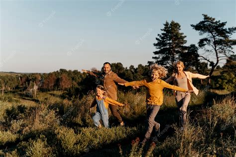 Free Photo | Full shot family running on meadow