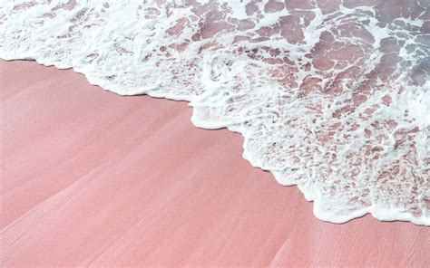 Download A Pink Sand Beach With Waves And A Pink Sand | Wallpapers.com