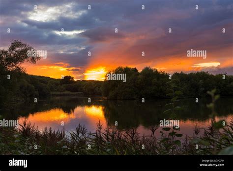 sunset and rain clouds over Hosehill Lake, Theale, UK Stock Photo - Alamy