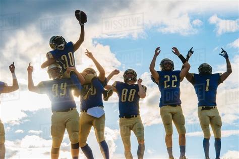 Group of young american football players, celebrating - Stock Photo - Dissolve