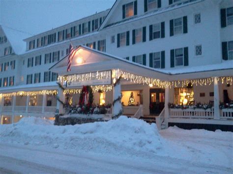 a large white building with christmas lights on it's windows and snow ...