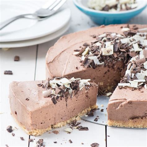 A slice of no-bake chocolate cheesecake next to the remaining c ...