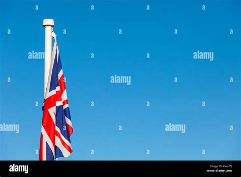 Union Jack flag on a bright blue sky background Stock Photo - Alamy