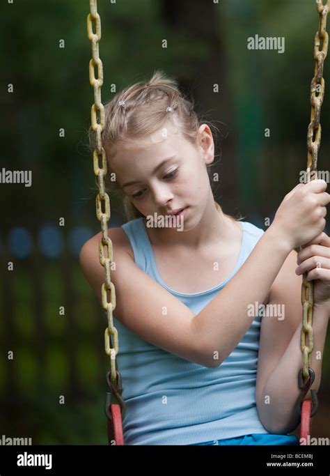 Child in a somber mood on a swing Stock Photo - Alamy