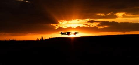 Premium Photo | Silhouette of drone flying at sunset