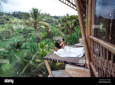 Couple enjoying morning vacations on tropical jungle villa bungalow ...