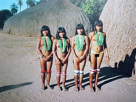 four women in bathing suits standing next to each other on the beach ...