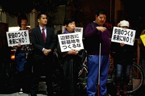 People hold slogans during a protest against Barack Obama's visit to Japan